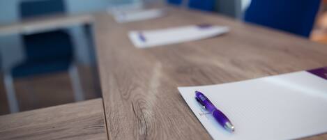 A conference table with a purple pen and a piece of paper.