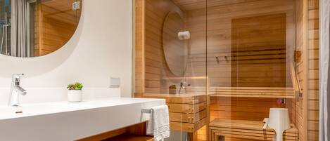 A modern bathroom with a wooden vanity, a large mirror, and a glass-enclosed shower area.