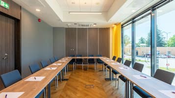 A conference room with a long table, chairs, and large windows.