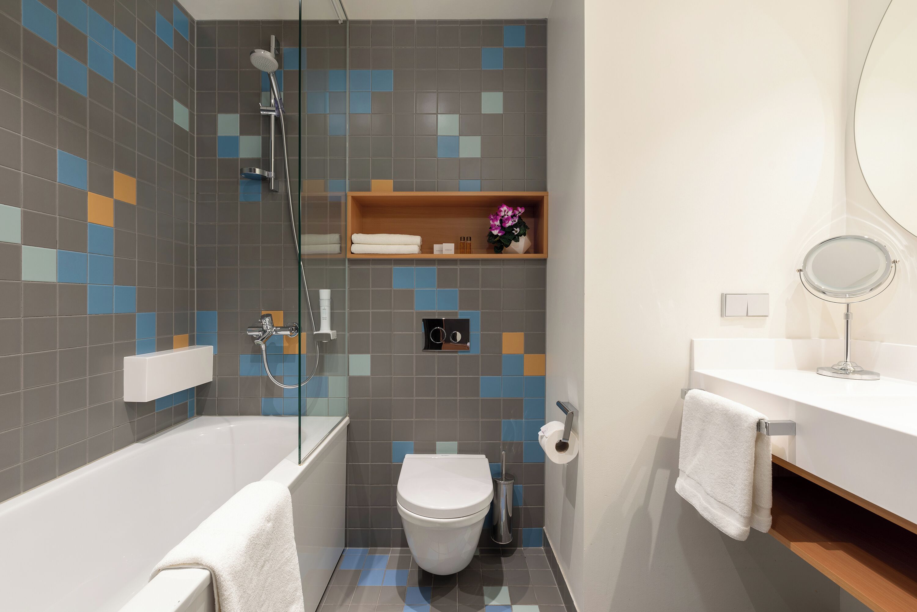 Een moderne badkamer met een bad, toilet en douche.