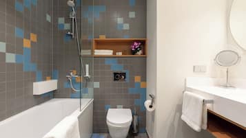 Een moderne badkamer met een bad, toilet en douche.