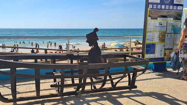 A beachside seating area with a map and informational sign.
