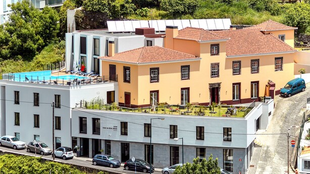 A hotel with a rooftop pool, a modern building with a flat roof, and a traditional building with a red-tiled roof. - Hotel Solar do Bom Jesus (Santa Cruz)