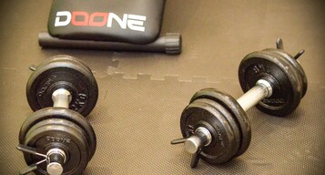 Dos pesas con la marca 'DOONE' sobre una superficie texturizada.