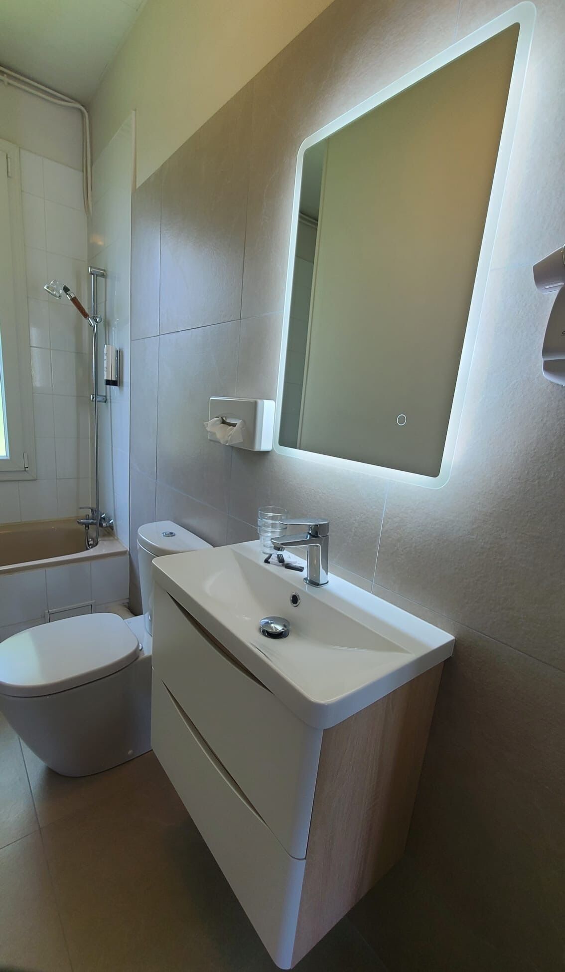 A modern bathroom with a toilet, sink, and shower.
