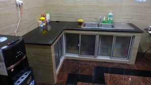 A compact kitchen with a built-in sink, a coffee machine, and a small countertop area. - The Backpacker Semarang - Hostel (Semarang)