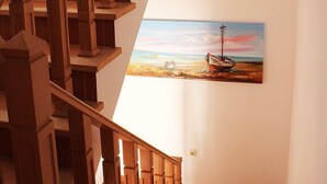 Una escalera de madera con un cuadro de un barco en la pared.