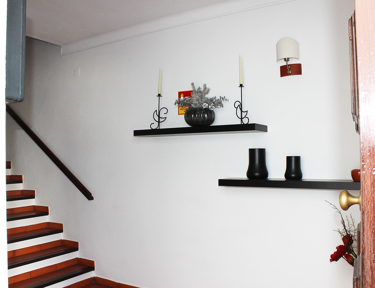 A staircase with wooden steps and a black handrail.