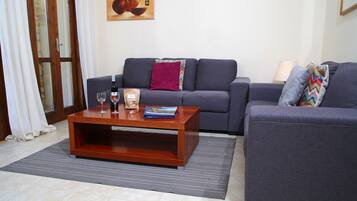 A living room with a sofa, a coffee table, and a rug.