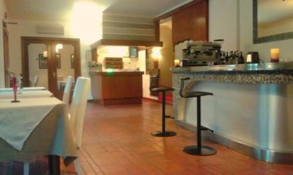 Zona de bar con taburetes, mostrador y máquina de café.