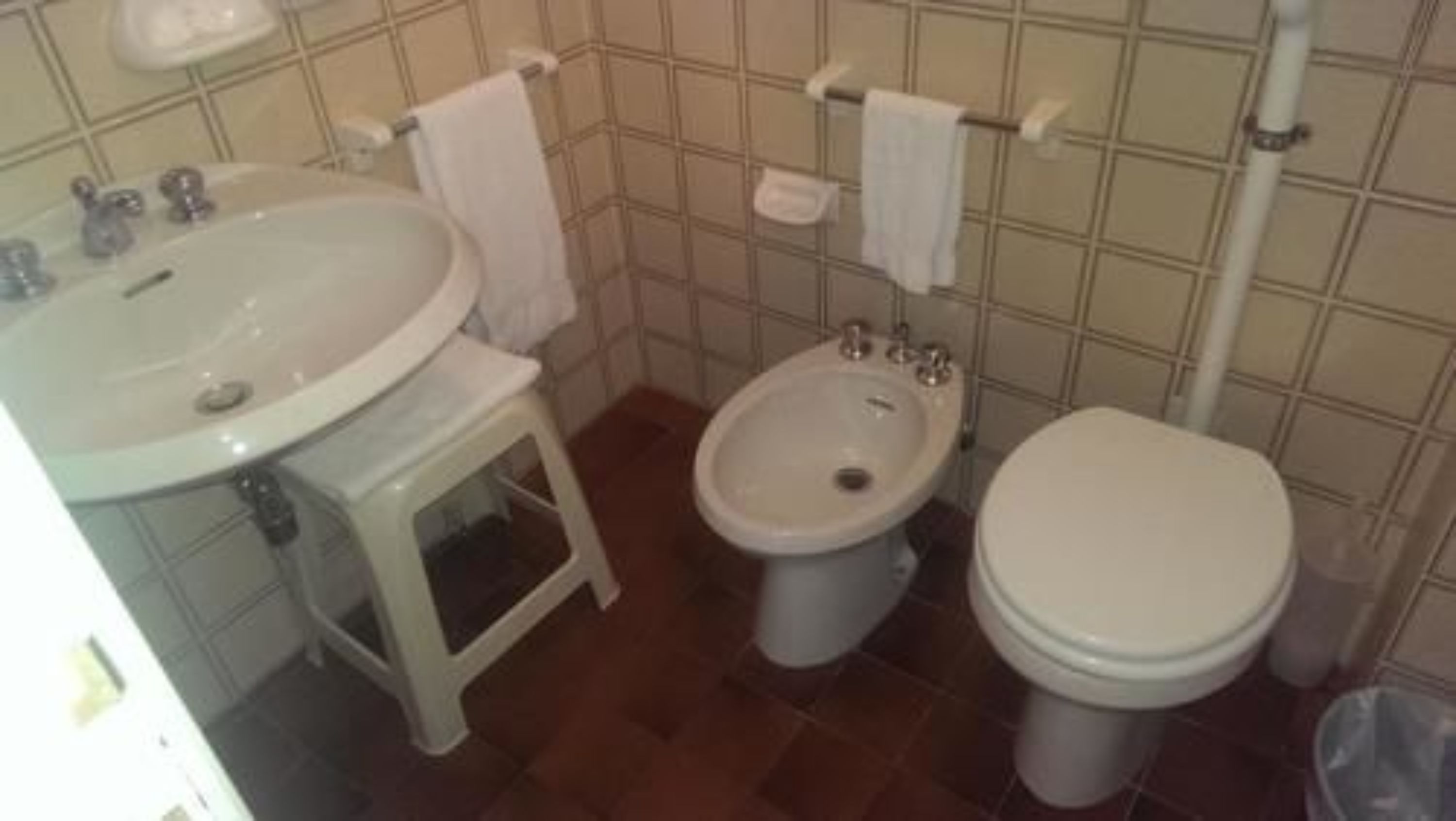 A bathroom with a sink, bidet, and toilet.