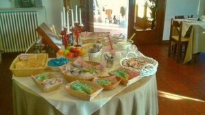 A buffet table with various food items and a candle centerpiece. - Hotel Cortina (Garda)