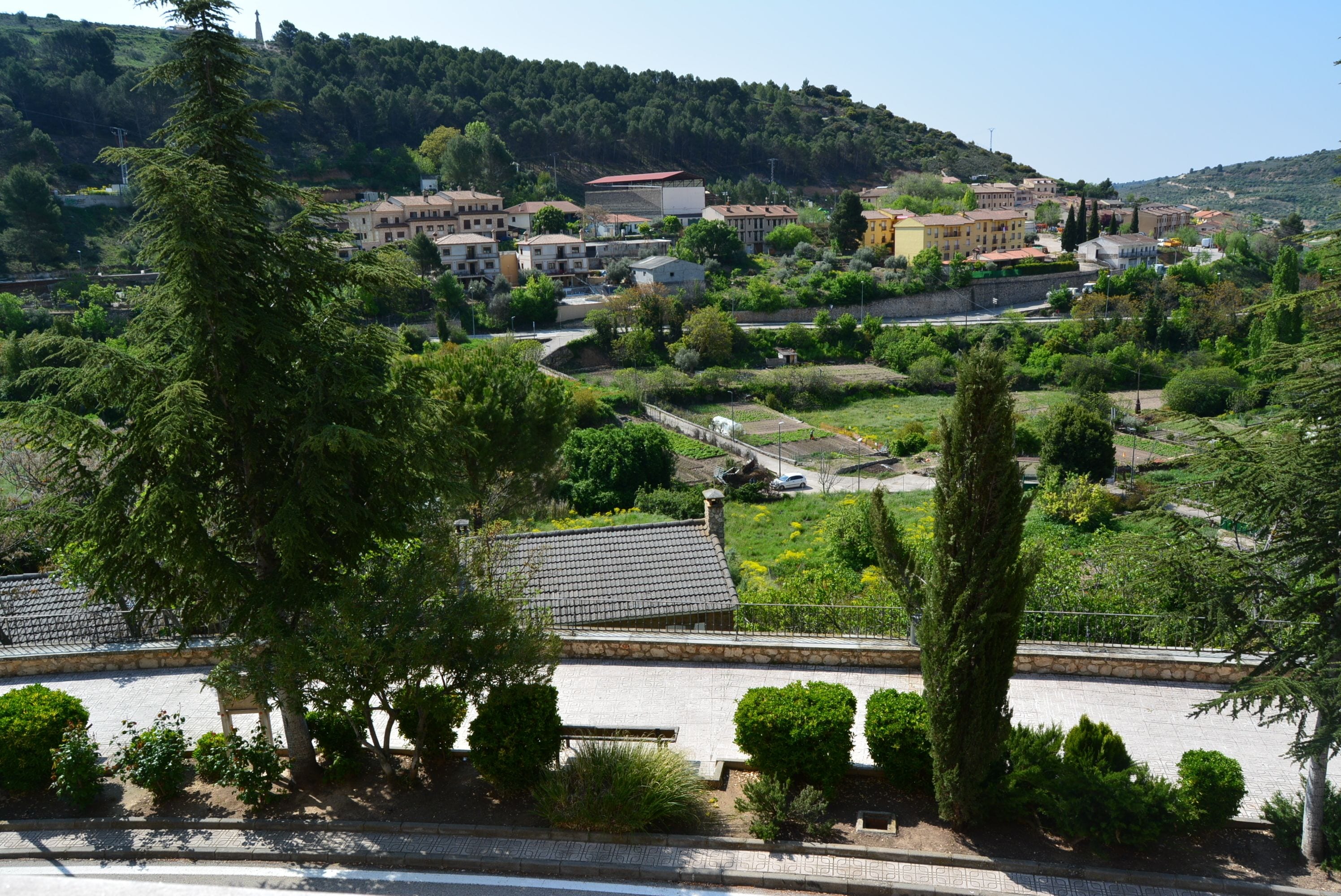 A hillside town with buildings, trees, and a road.