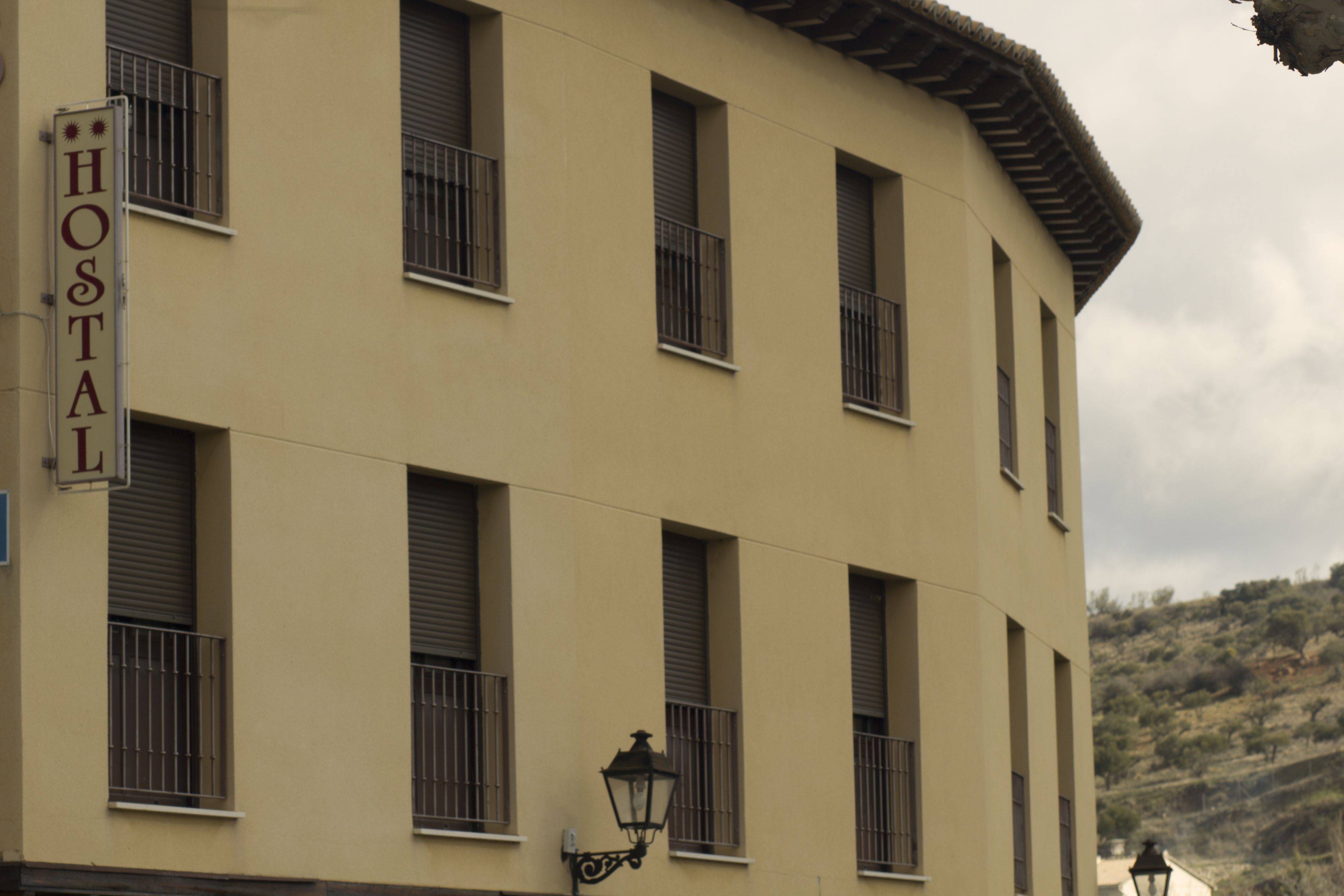 A building with a sign reading "HOSTAL" indicating it is a hostel.