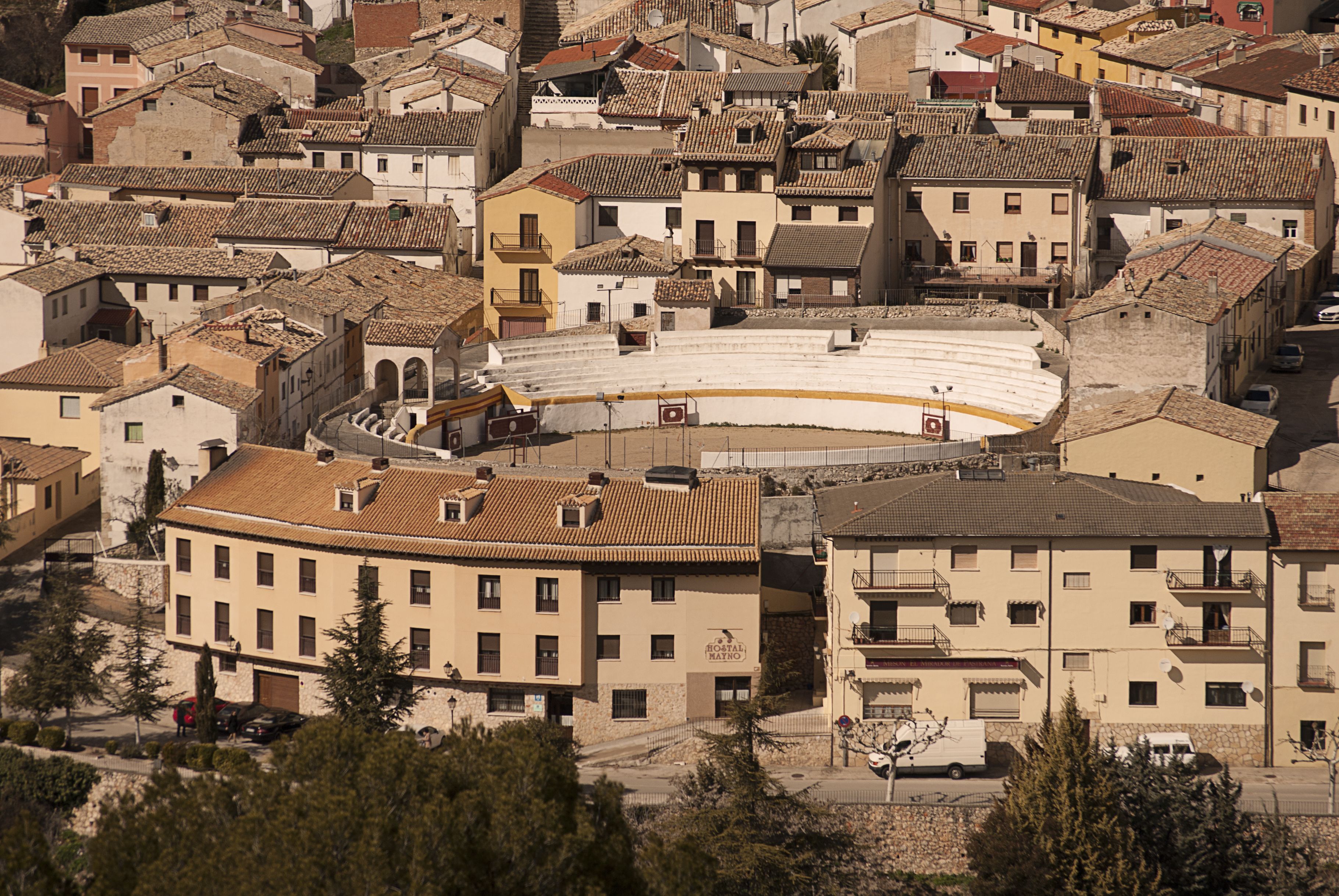 Un pueblo histórico con un anfiteatro central rodeado de edificios de varios pisos con balcones.
