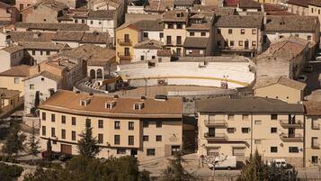 Un pueblo histórico con un anfiteatro central rodeado de edificios de varios pisos con balcones.
