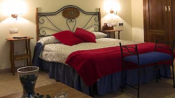 Une chambre à coucher bien rangée, avec un lit, des tables de chevet, une commode, une chaise et un vase rempli de fleurs.