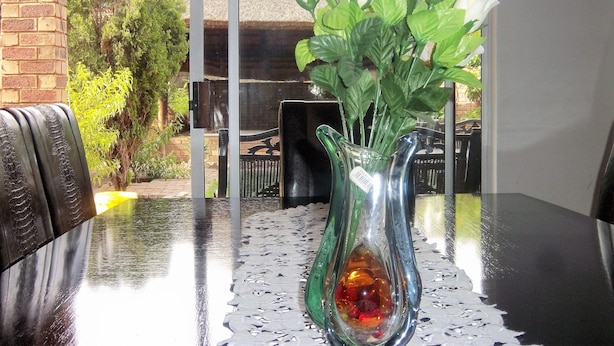 Ein Tisch mit einer Blumenvase und einer dekorativen Glasgießer.