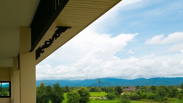 A hotel room with a view of lush green hills and mountains. - SakSukSmile Resort (Sukhothai)