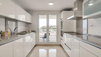 Frigorífico grande, horno, placa de cocina y cafetera o tetera