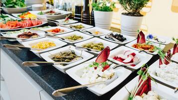 A buffet with various food items and utensils.
