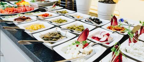 A buffet with various food items and utensils.