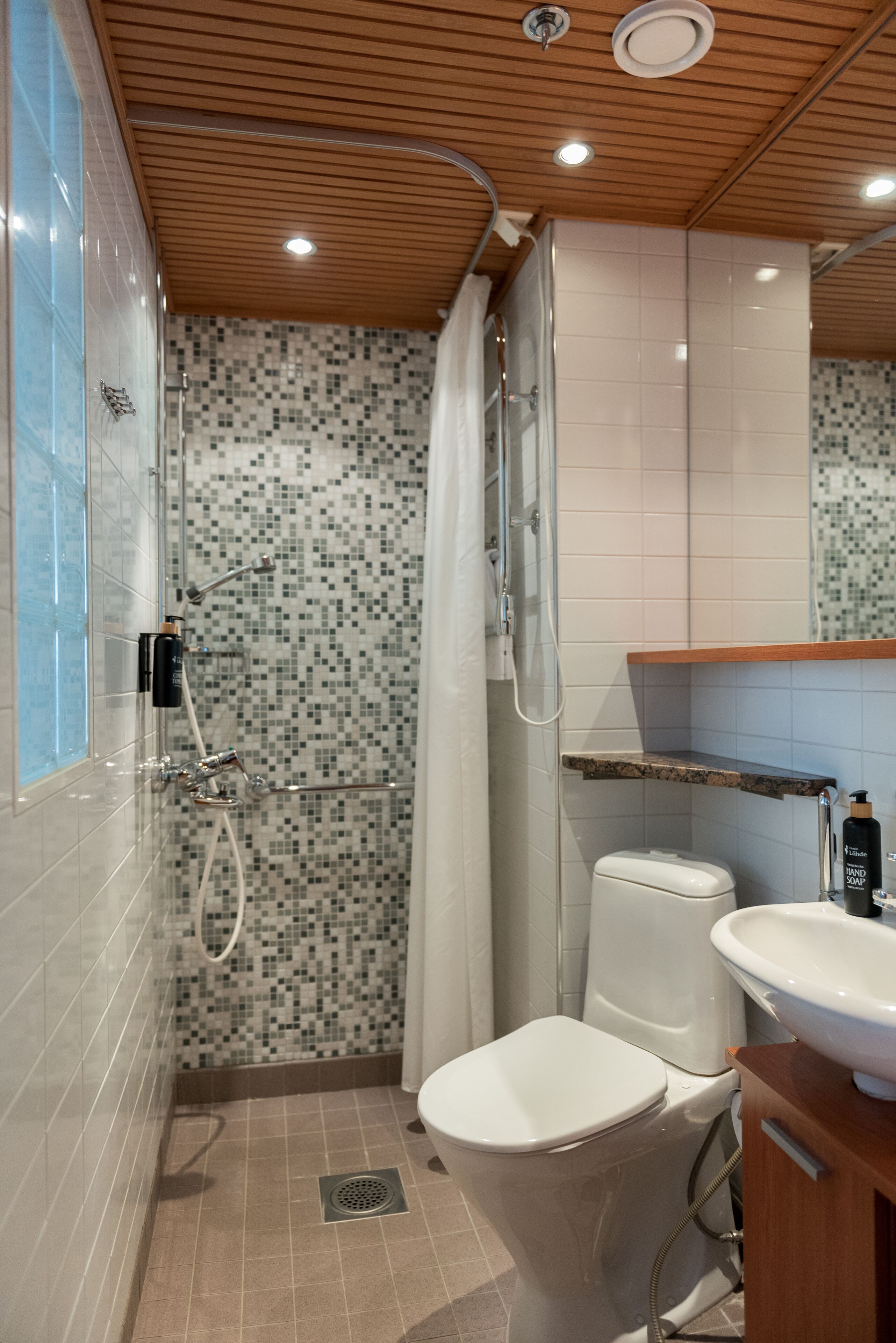 A bathroom with a shower, toilet, and sink.