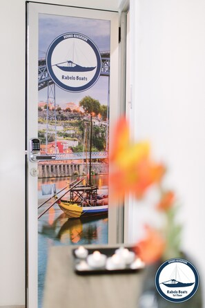 A door with a mural of a boat and a bridge, and a logo for 'Douro Riverside Rabelo Boats'. - Douro Riverside Apartments (Vila Nova de Gaia)