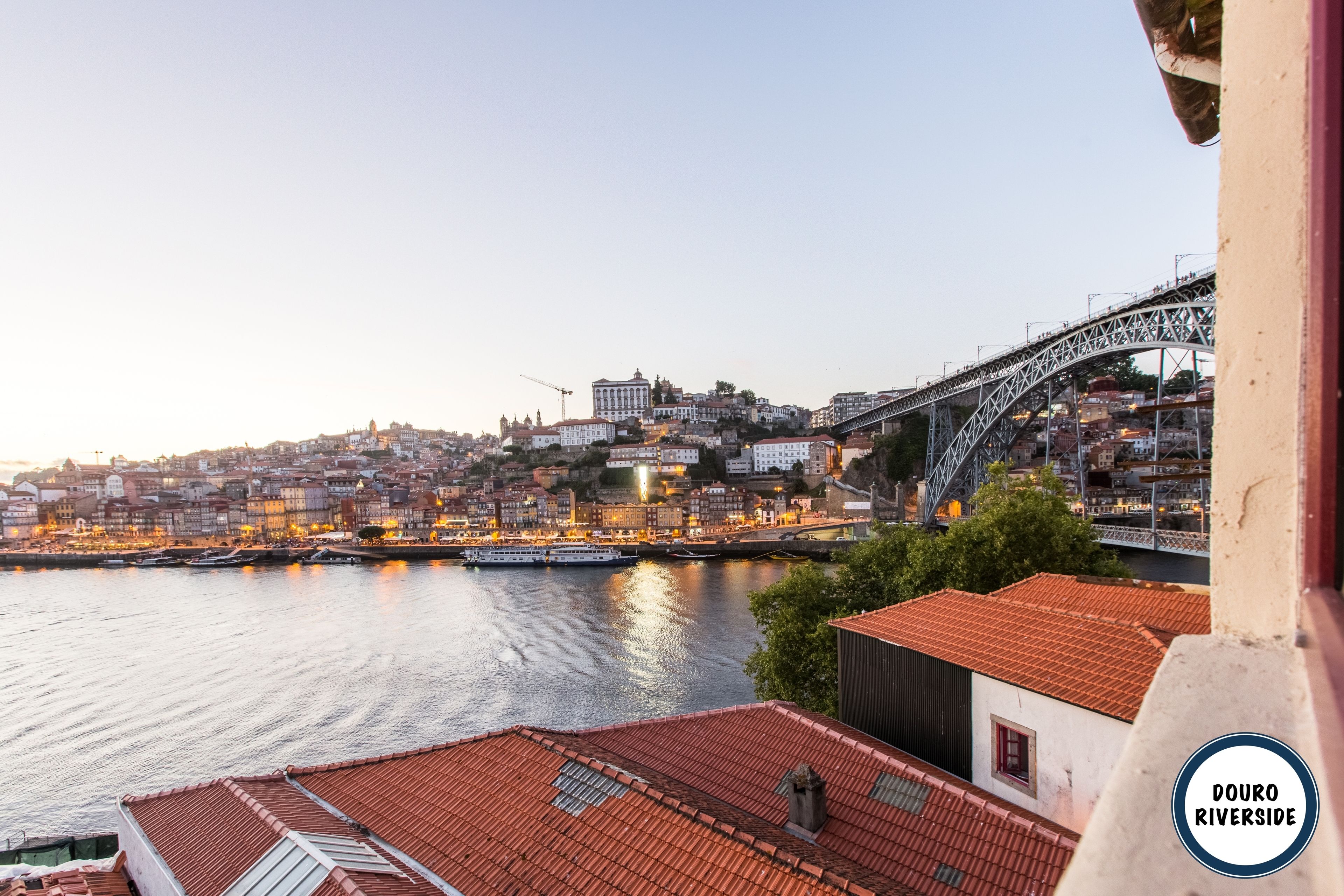 Een uitzicht op de Douro-oever met een brug en gebouwen langs de rivier.