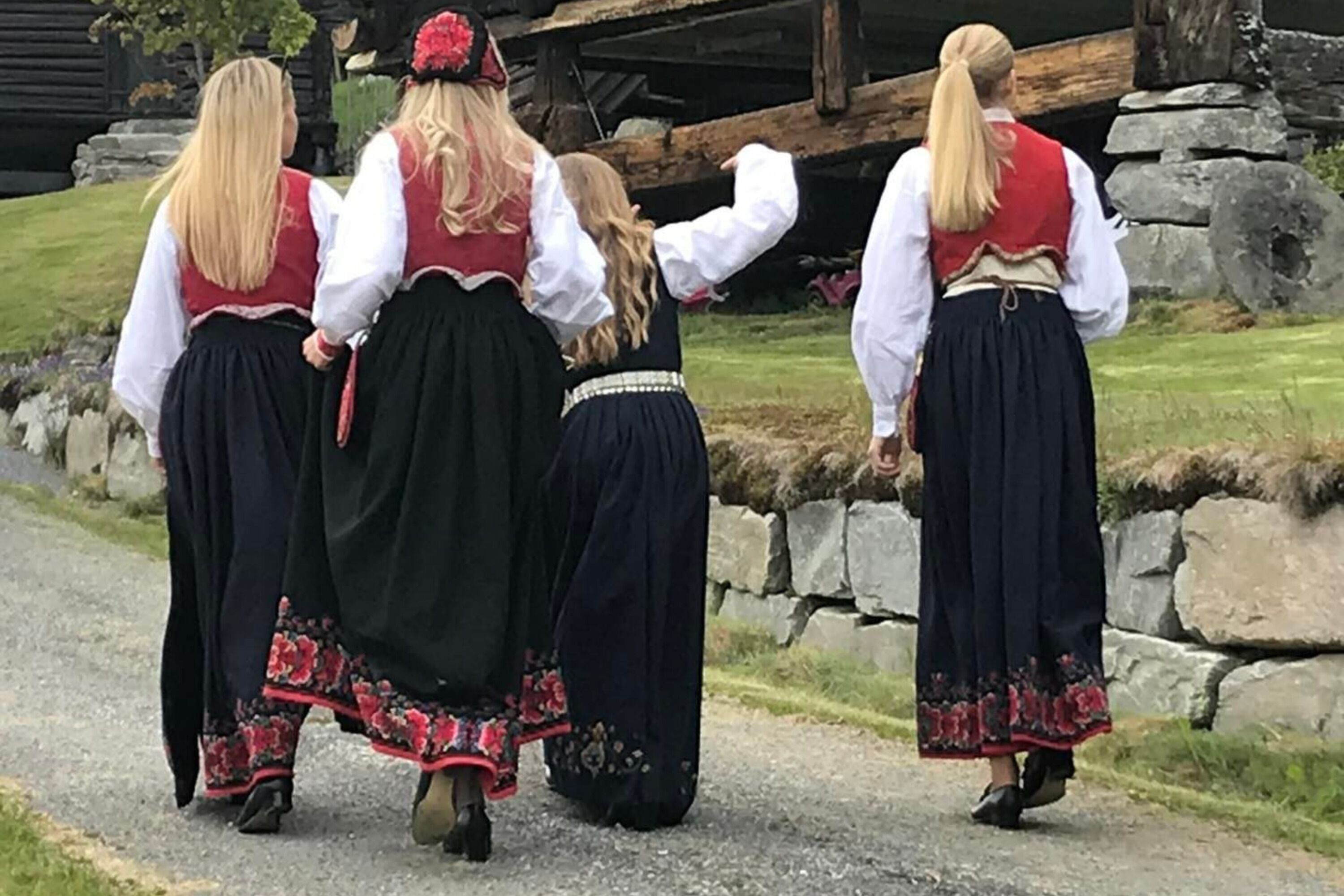 Un grupo de personas vestidas con atuendos tradicionales caminando por un sendero.