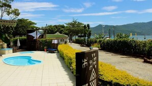 A swimming pool, a covered seating area, and a sign with symbols. - Pousada Ilha da Magia (Florianópolis)