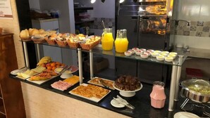 A buffet with various food items including fruits, pastries, and beverages. - Pousada Ilha da Magia (Florianópolis)
