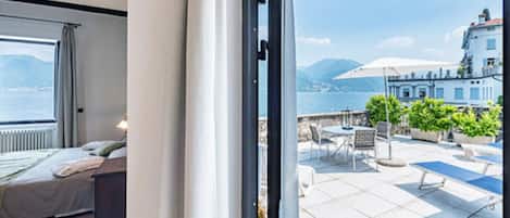 Un dormitorio con cama y vista al mar a través de una ventana.