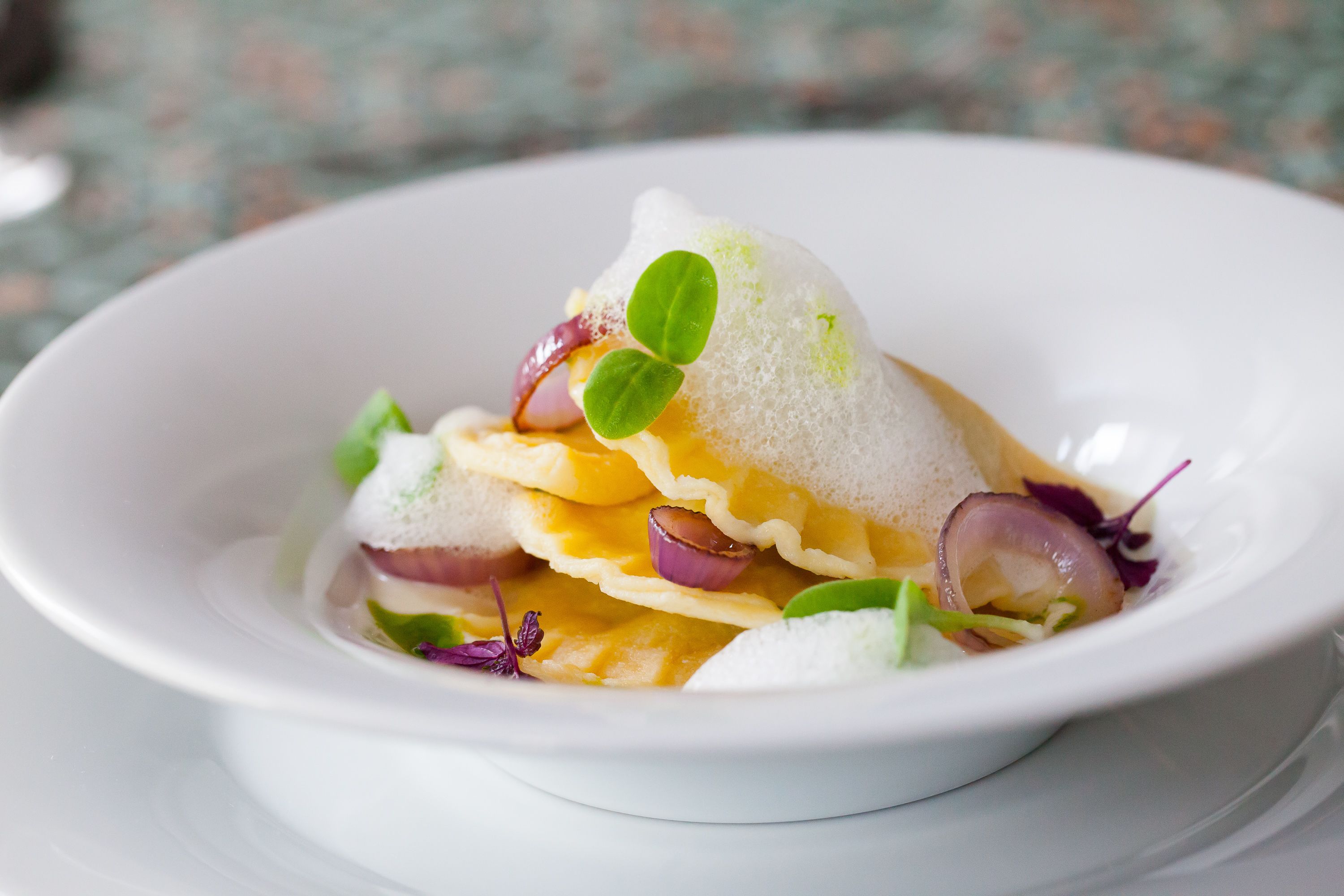Un bol blanc amb un plat en capes i diversos ingredients.