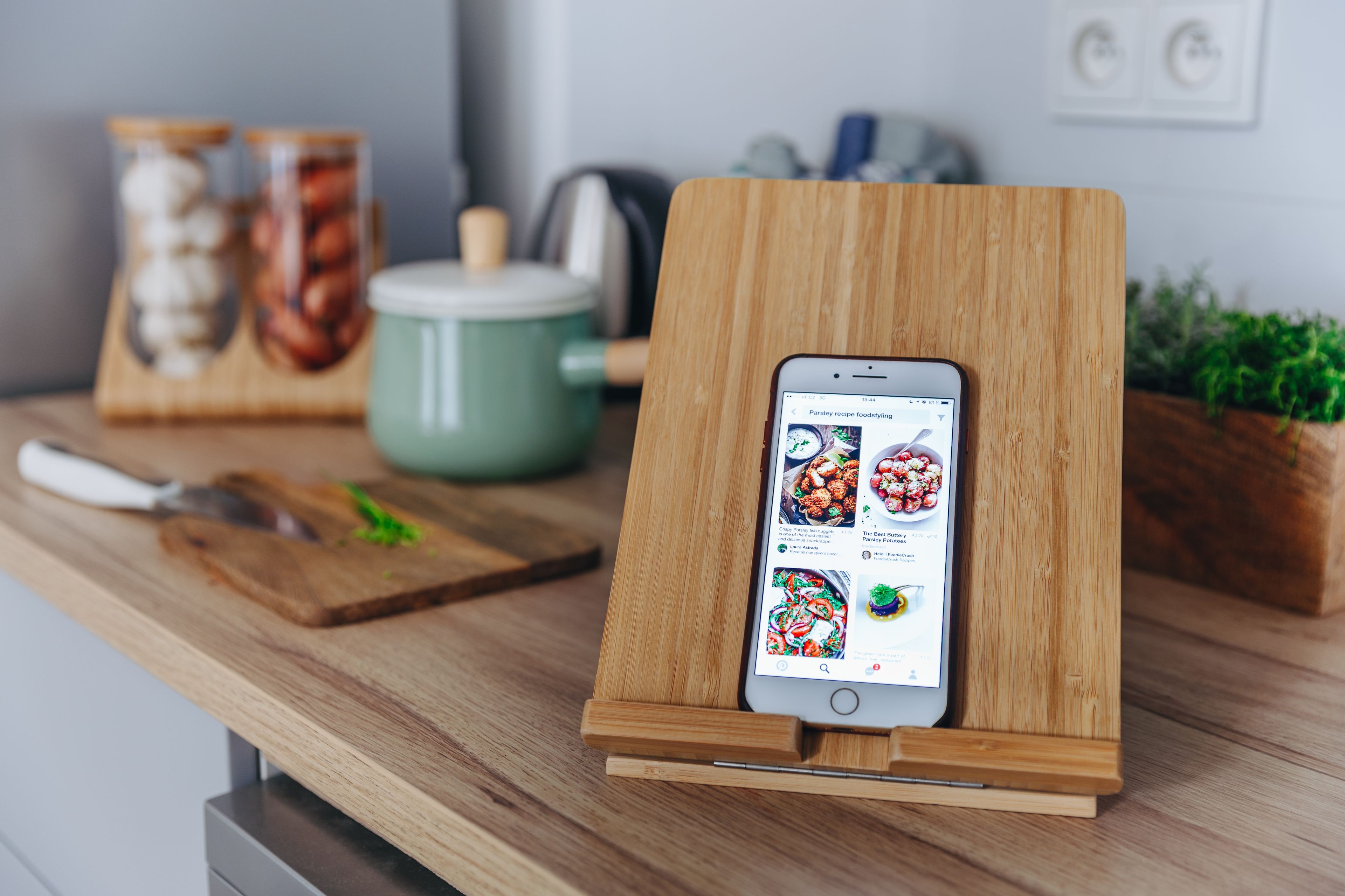 Ein Smartphone auf einem Holzständer, das eine Rezept-App anzeigt.