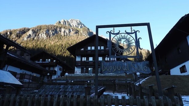 Eine Berghütte mit einem Schild, auf dem "Borgo del Sol" steht.