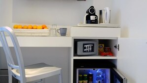 A compact room with a desk, chair, TV, and mini-fridge. - M2M Made To Measure (Milan)