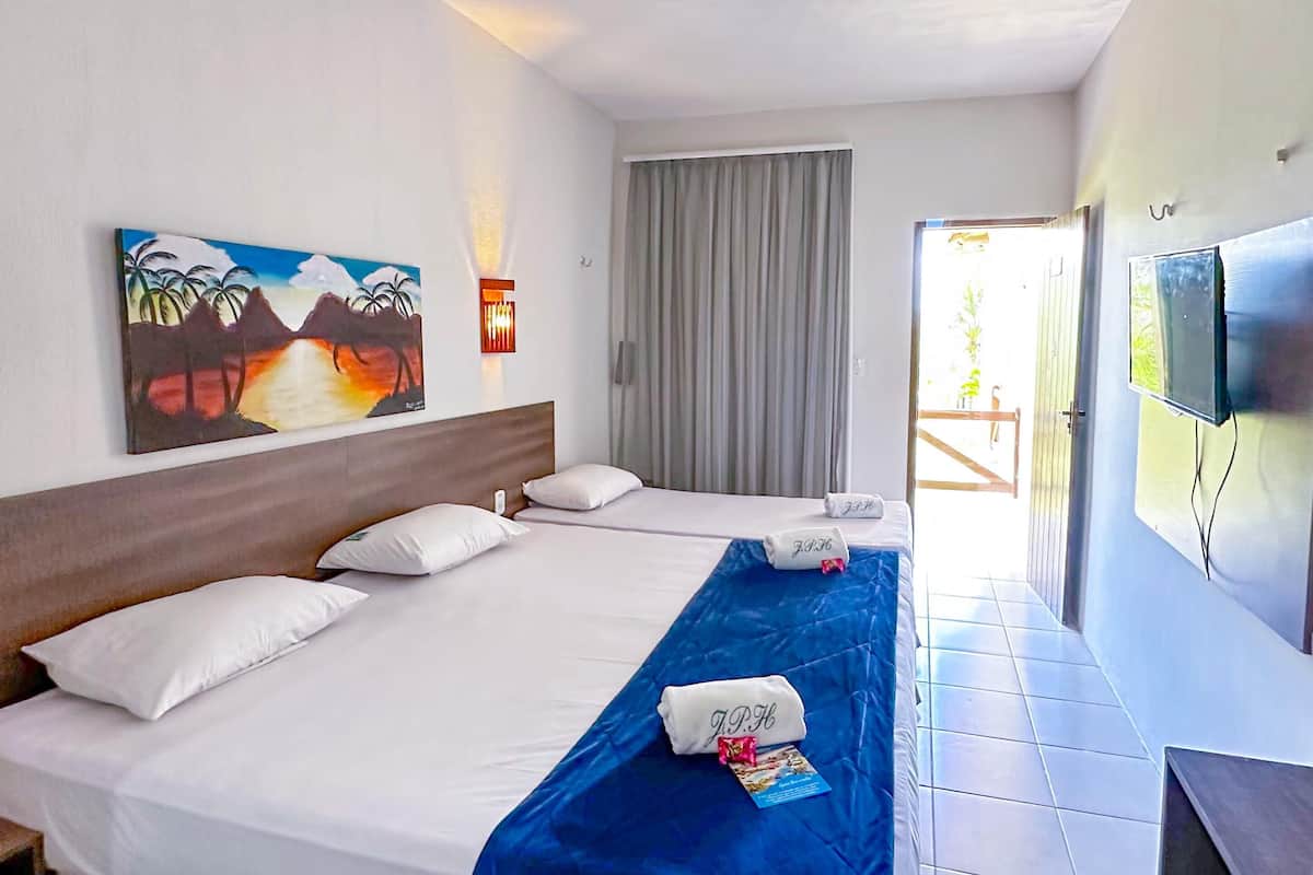 A hotel room with two beds, a painting on the wall, a TV, and a window with curtains.