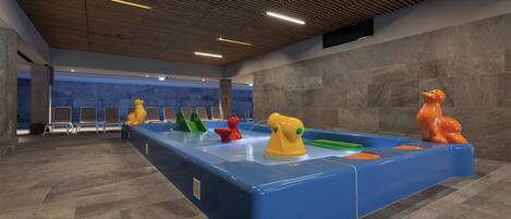 A swimming pool with colorful animal-shaped floats and a modern ceiling design.