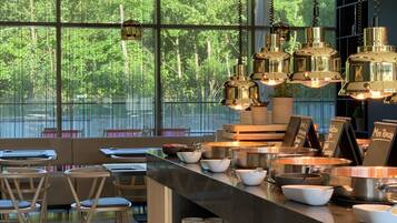 Una cocina moderna con barra, ventanas amplias y lámparas colgantes.