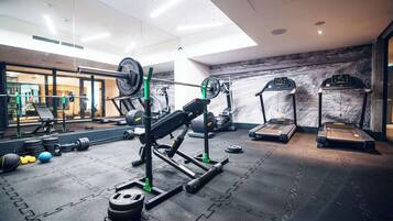 A gym with weightlifting equipment, treadmills, and exercise balls.