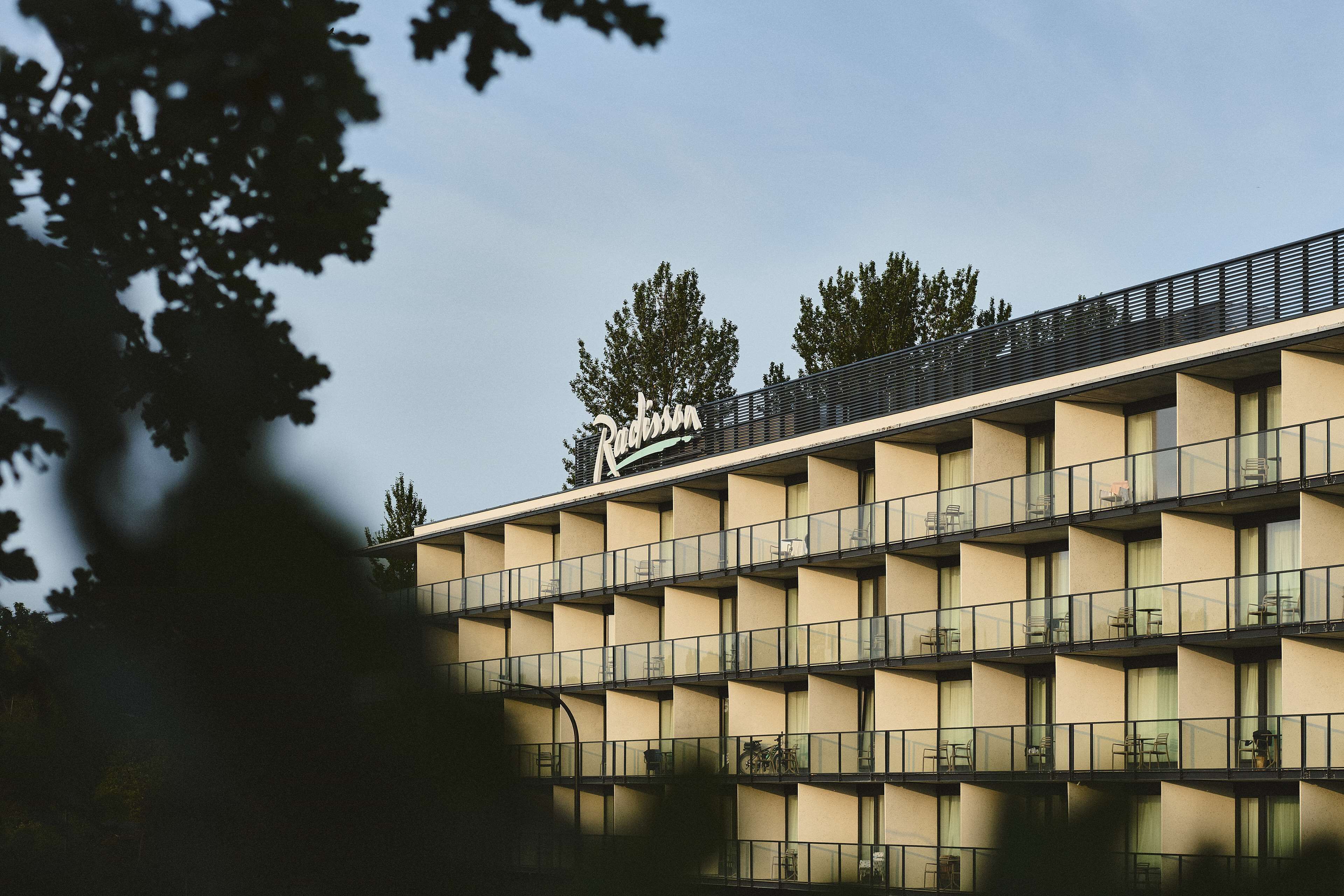 Un hotel de varios pisos con un diseño arquitectónico moderno, que cuenta con un letrero llamativo en la parte superior.