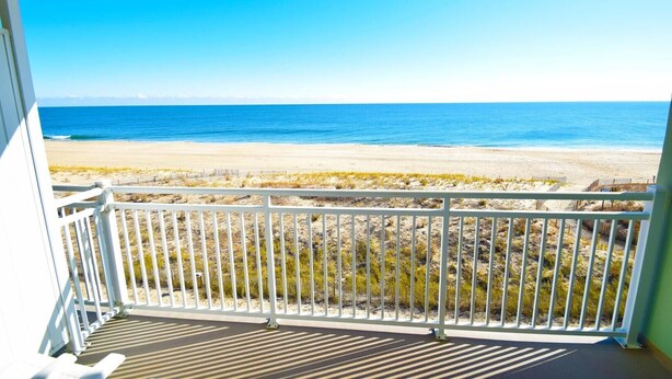 A balcony with a view of a beach and ocean. - Worcester House 503 by RedAwning (Ocean City)
