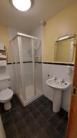 Un baño con ducha, inodoro y lavabo.