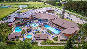 Un resort con varias piscinas, tumbonas y un amplio estacionamiento.