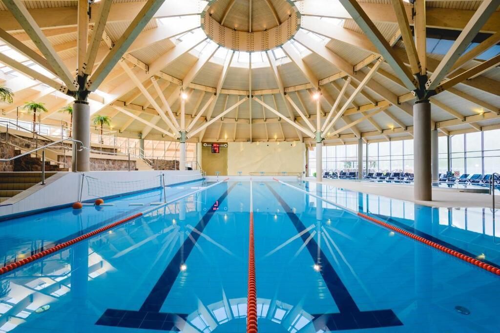 Une piscine intérieure dotée d'un plafond haut et de plusieurs couloirs de nage.