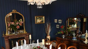 A formal dining room with a long table set for a meal, surrounded by wooden chairs. - Glenduff Manor House (Tralee)