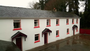 A white building with red trim and multiple windows. - Glenduff Manor House (Tralee)
