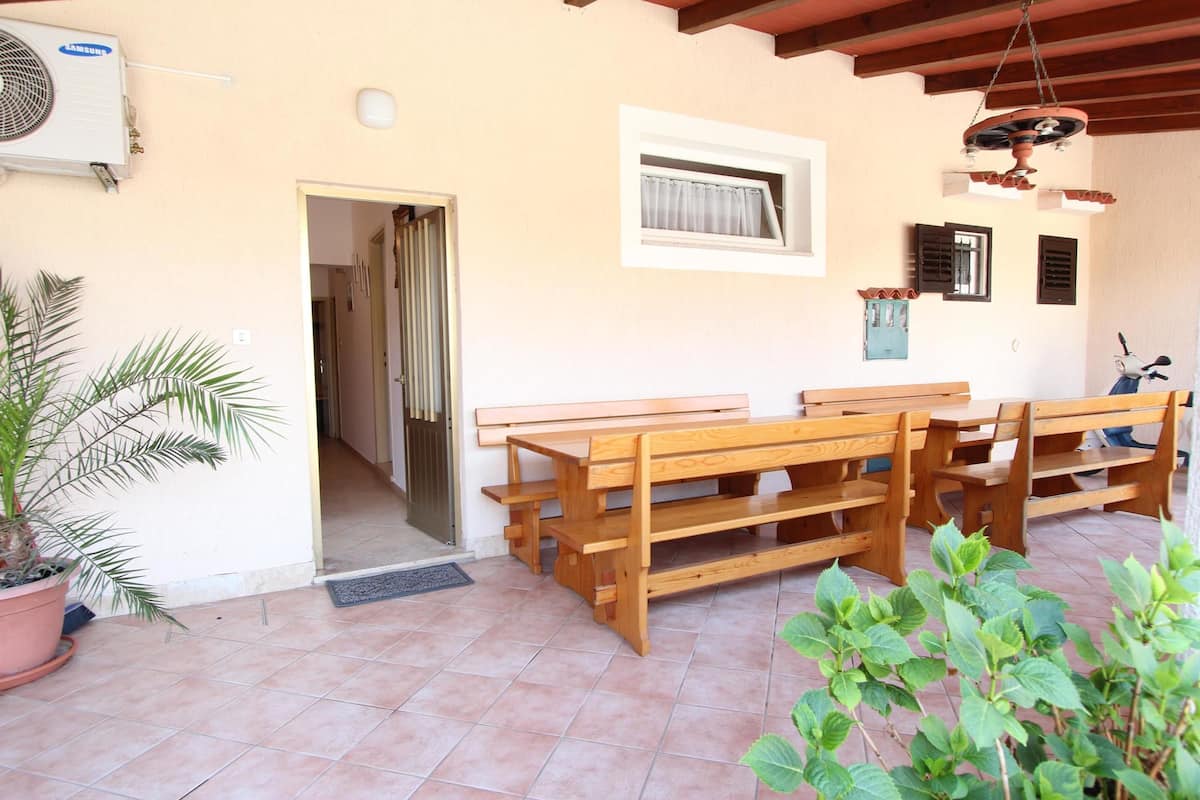 Un patio con bancos de madera y una planta en maceta.