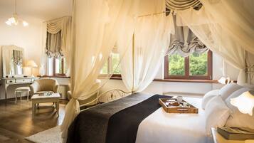 A bedroom with a bed, bedside table, lamp, and a window with curtains.